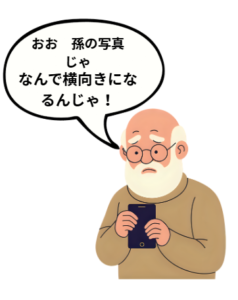 おお、孫の写真じゃ…って、なんで横向きになるんじゃ！とiPhoneの画面を見つめるおじいちゃんの画像です。